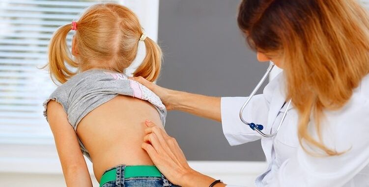 médecin examinant le dos d'un enfant souffrant de douleurs lombaires